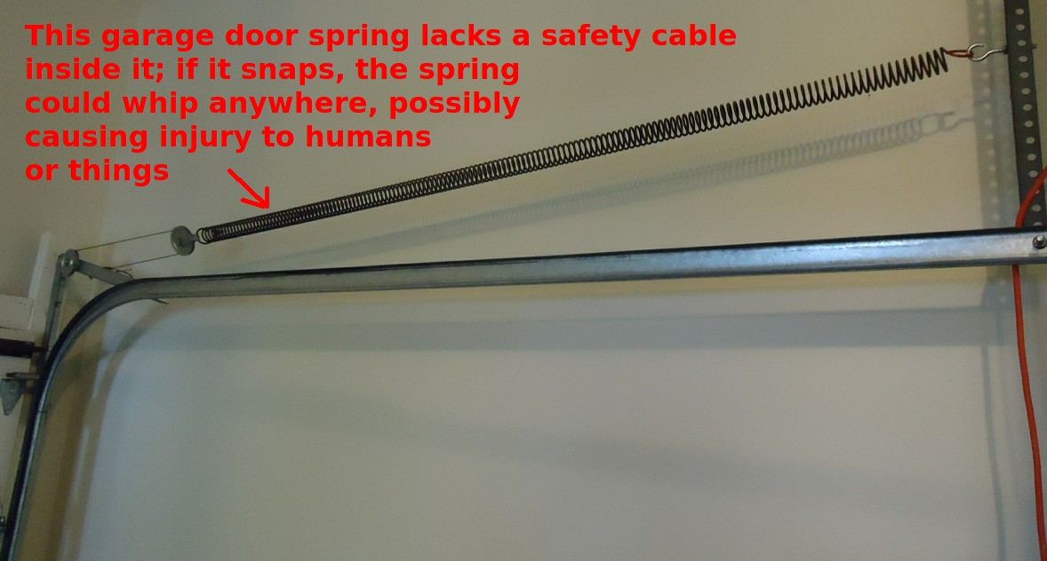 Garage door extension spring missing a safety cable beside its track